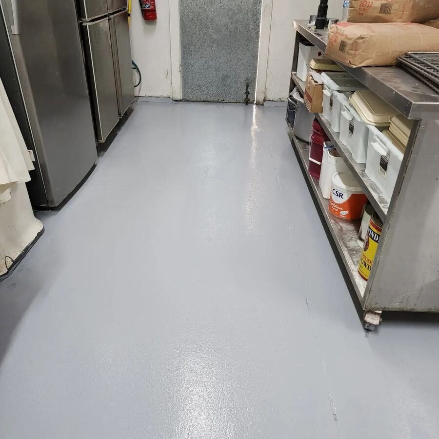Grey resin floor beside refrigeration equipment in a commercial food area