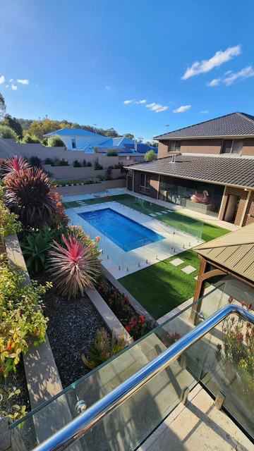 Pool area with garden and glass fencing