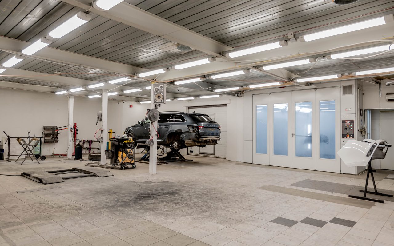 Car repair workshop with an oil-stained floor, relevant to mechanic workshop floor paint