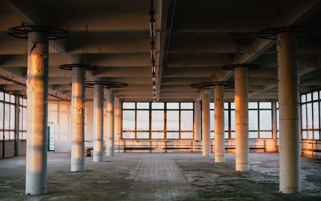 Empty factory floor with columns, showing the space a floor upgrade shutdown has to clear